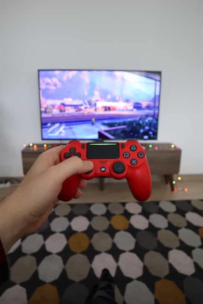 hand showing a game controller and the tv 