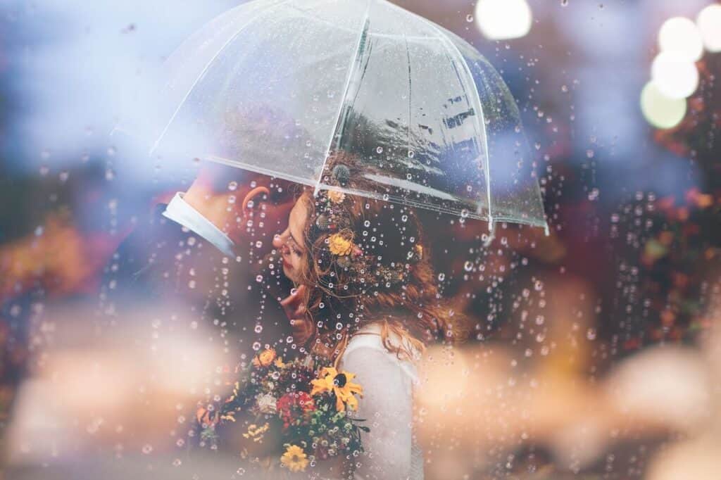 Couple Standing under umbrella with flowers 