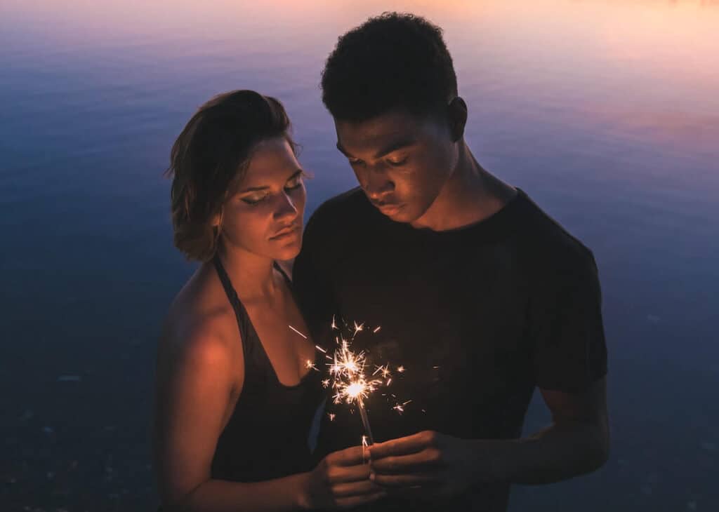couple holding a sparkler in the summer