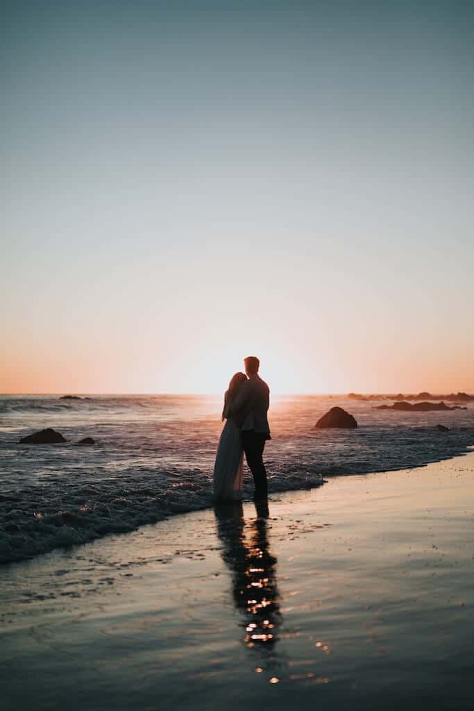 couple watching the sunset in the ocean 