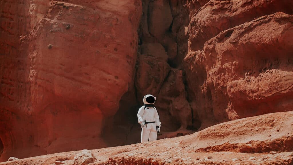 Man in space uniform by red rocks
