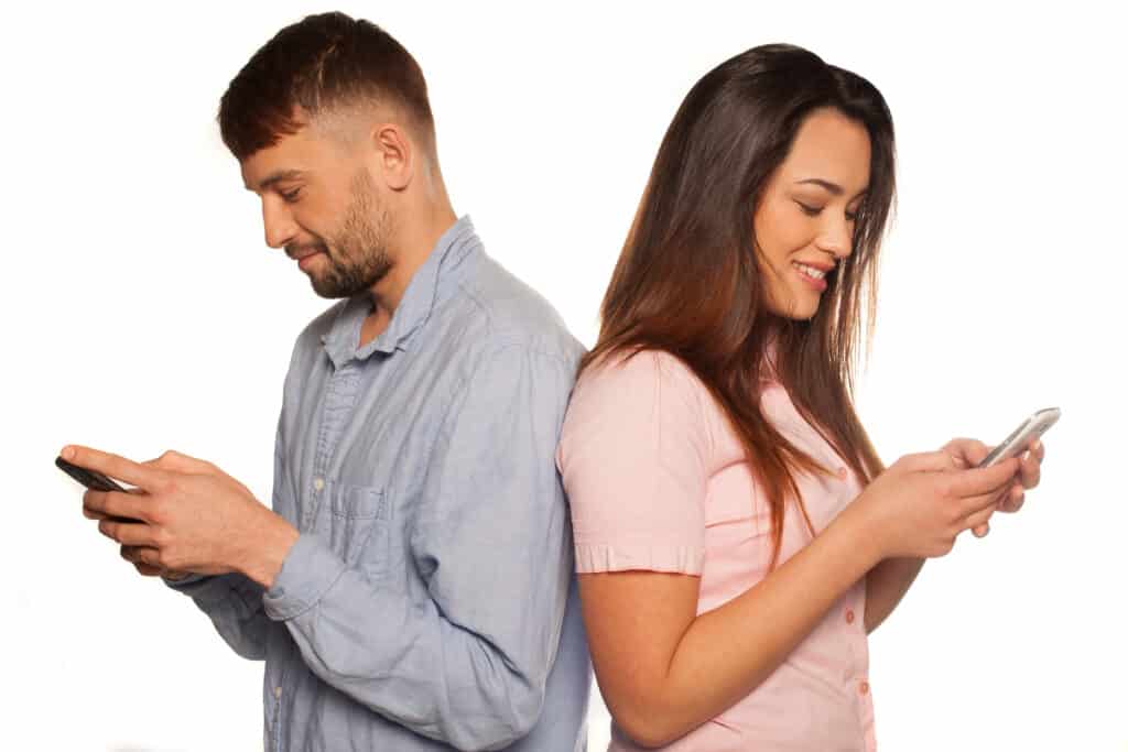 image shows a young couple texting through cellular phones.