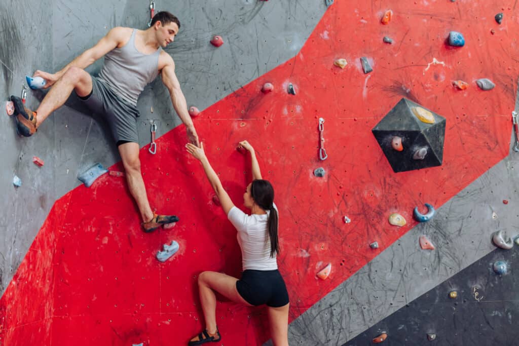 a couple on an indoor rock climbing wall.
