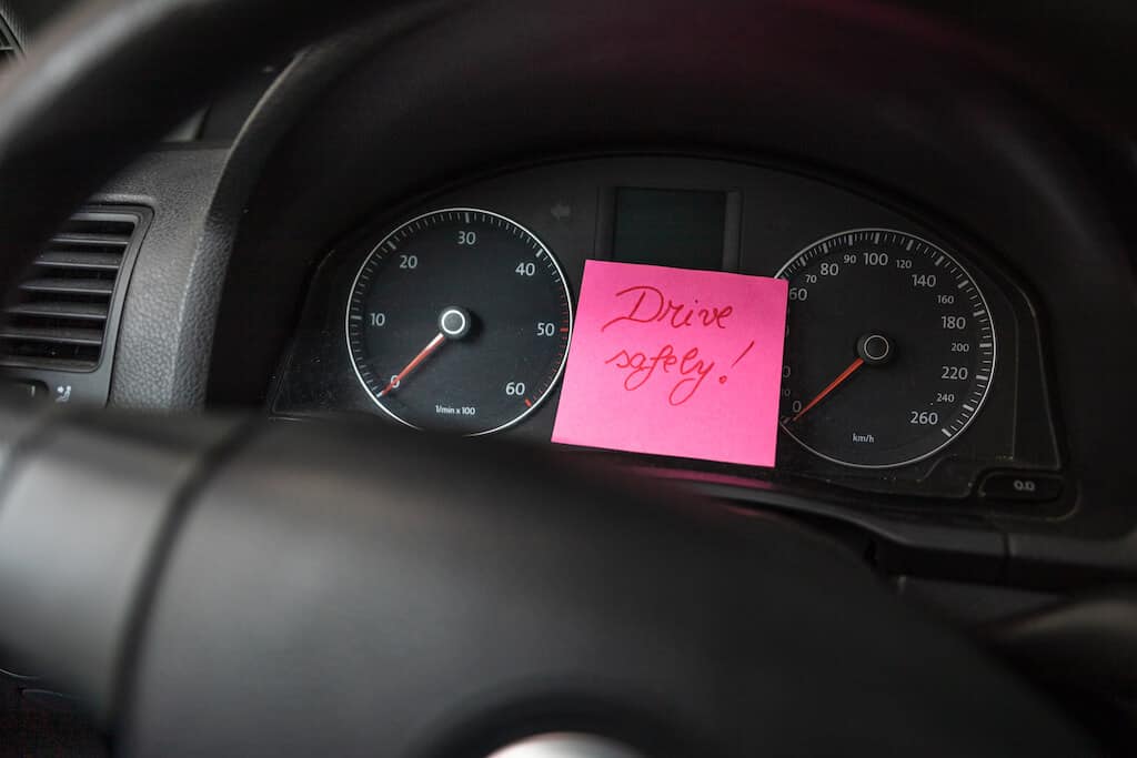 note to boyfriend says "drive safely!" on a post it on the dash of car. 